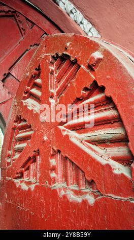 Dieses Foto zeigt die reiche Textur der alten roten Holztore in der Jaroslaviv-Val-Straße in Kiew. Die verwitterte Oberfläche, architektonische Details Stockfoto