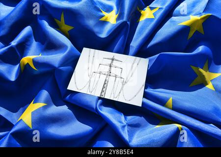 FOTOMONTAGE, Hinweis mit Hochspannungsmast auf EU-Flagge, symbolisches Foto der Strommarktreform, FOTOMONTAGE, Zettel mit Hochspannungsmast auf EU- Stockfoto