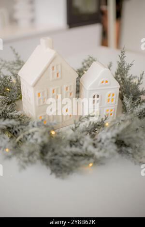 Miniaturhäuser und Tannen auf weißem Hintergrund. Gemütliche kleine Welt. Weihnachtsdekoration, Weihnachtskonzept. Stockfoto