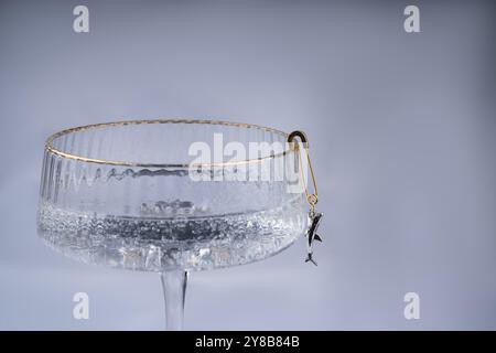 Schmuck im Glas. Ein volles Glas Champagner. Ein Glas mit einer Kette, die mit Wasser gefüllt ist. Stockfoto