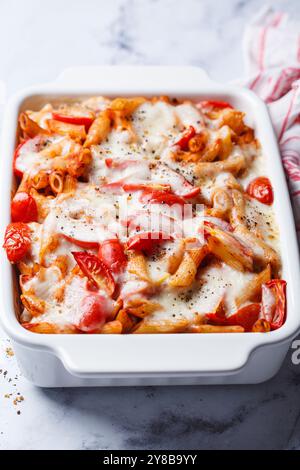 Gebackene Nudeln mit Tomaten und Mozzarella in einer Ofenform. Stockfoto