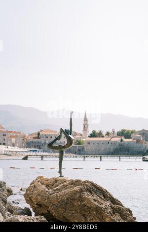 Statue eines tanzenden Mädchens auf einem Felsen vor der Küste von Budva. Montenegro Stockfoto