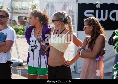 DREI VOLLEYBALLSPIELER SCHAUEN ZU, BEACHVOLLEYBALL, MARIEHAMN, 2011: Drei Volleyballspieler beobachten während der Qualifikationsstufen. An einem ungewöhnlich heißen Sommertag in der Ostsee im August 2011 bei den PAF Open in Mariehamn, Åland, Finnland, beobachten die Menschen die Beachvolleyball-Action auf den Außenplätzen in Sommerkleidung oder Strandbekleidung. Foto: Rob Watkins. INFO: Das PAF Open Beach Volleyballturnier fand zwischen 2009-2013 in Mariehamn, Åland, Finnland statt. Es zog die besten internationalen Teams und Spieler als Rangliste der offiziellen FIVB World Tour, Showcasi, an Stockfoto