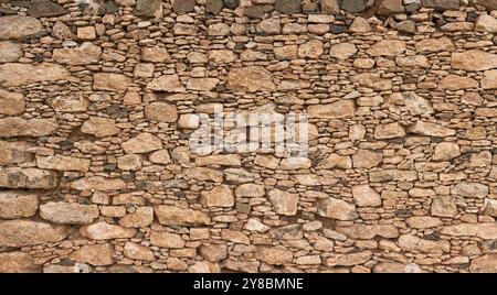 Braune Natursteinmauer mit Muster von großen und kleinen Steinen auf Fuerteventura Stockfoto