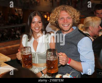 München, Deutschland, 01. Oktober 2024: Fussball, Herren, 3.Liga, Saison 2024/2025, TSV 1860 München, Wiesn, Wiesnbesuch, Oktoberfest, Hacker Festzelt Jesper Verlaat (TSV 1860 München) (re.) Sitztend mit einer Mass Bier in der Hand, hier mit seiner Begleitung (li.) Stockfoto