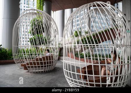 01.08.2023, Singapur, Republik Singapur, Asien - Personen sitzen an Tischen in vogelkaefig-artigen Sitzbereichen auf einer von vier Ebenen des vertikalen Gartens Green Oasis im neuen CapitaSpring Wolkenkratzer im zentralen Geschaeftszentrum am Raffles Place. Das Gebaeude wurde vom daenischen Architekturbuero Bjarke Ingels Group BIG entworfen. *** 01 08 2023, Singapur, Republik Singapur, Asien Menschen sitzen an Tischen in Vogelkäfig-ähnlichen Sitzbereichen auf einer der vier Ebenen des vertikalen Gartens Green Oasis im neuen CapitaSpring Hochhaus im zentralen Business Center von Raffles Place the Buil Stockfoto