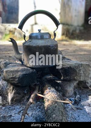 Wasser im Wasserkocher heizen am Lagerfeuer im Wald Stockfoto