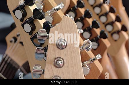 Gruppe von Gitarren, traditionelle Saiteninstrumente. Nahaufnahme von Kopfstöcken, abstrakter Hintergrund aus der Musikindustrie. Stockfoto