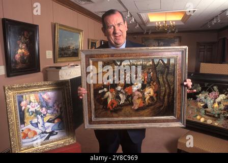 Richard Green, Kunsthändler in seiner Galerie Bond Street mit einem Pieter Brueghel dem Jüngeren, den er erworben hatte. London, England um die 1995 1990er Jahre Großbritannien HOMER SYKES. Stockfoto