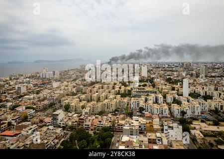 Lima, Peru - 12. Februar 2024: Dichte Rauchsäule im Luftbild im Stadtteil San Miguel Stockfoto