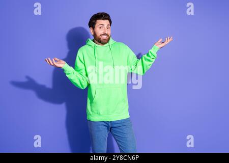 Foto von gutaussehendem reifem Alter funky Mann mit hellgrünem Hoodie absolut gleichgültig Shurger Schultern isoliert auf violettem Hintergrund Stockfoto