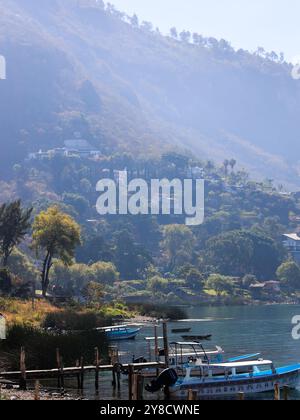 Lake Atitlan, Guatemala. Steg im Dorf Palopo. Ruhiger See im guatemaltekischen Hochland, Zentralamerika. Der Hügel ist mit dickem Laub bedeckt. Stockfoto