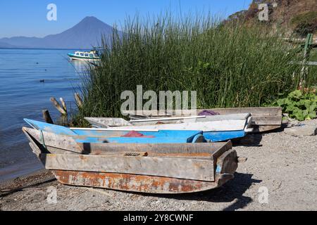 Lake Atitlan, Guatemala. Dorf Palopo. Ruhiger See im guatemaltekischen Hochland, Zentralamerika. Original ausgegrabene Kanus an Land mit Vulkanhintergrund. Stockfoto