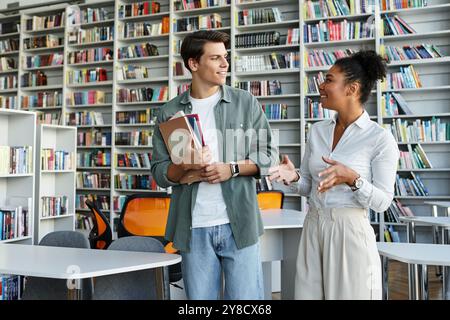 Eine engagierte Lehrerin teilt ihr Wissen mit ihrer aufmerksamen Schülerin in einer lebhaften Bibliotheksatmosphäre. Stockfoto