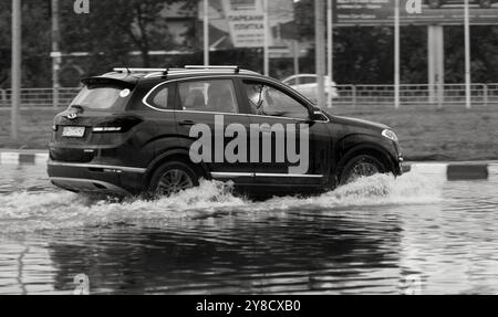 ODESSA, UKRAINE-September 5,2024: Nach starken Regenfällen bildeten sich Staus auf den Straßen, Autos werden mit Wasser übergossen und stehen. Autos schweben in Pfützen auf dem Stockfoto