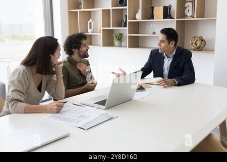Junger Geschäftsmann indischer Ethnizität berät Klienten in modernen Büros Stockfoto