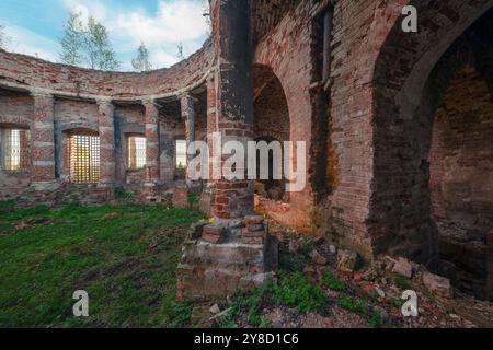 Backsteinruinen einer verlassenen Kirche. Säulenhalle mit eingestürztem Dach Stockfoto