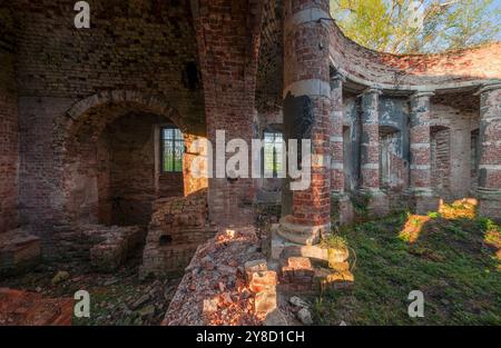 Backsteinruinen einer verlassenen Kirche. Säulenhalle mit eingestürztem Dach Stockfoto