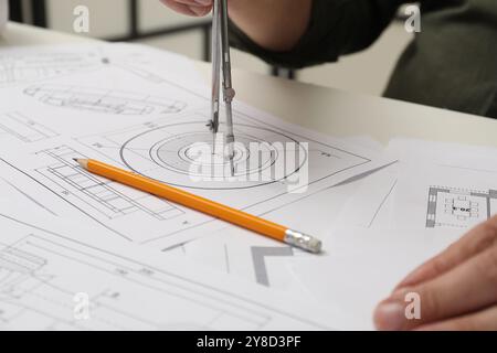 Ingenieur, der mit Projekt arbeitet, Nahaufnahme. Verschiedene technische Zeichnungen auf weißem Tisch Stockfoto