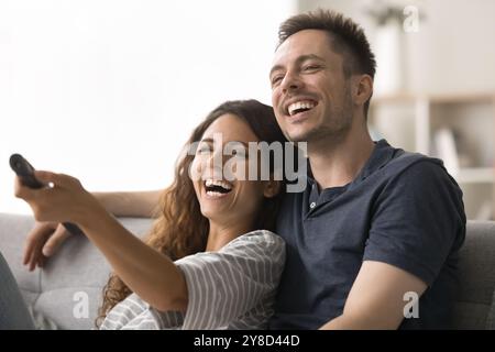 Fröhliches, überfröhliches junges Paar, das lustige Fernsehsendungen ansieht Stockfoto