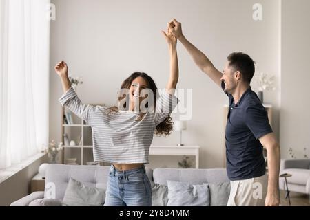 Positiver junger Mann und Frau, die sich in einem neuen Zuhause amüsieren Stockfoto
