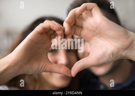 Hand Herzform mit glücklichen Gesichtern des jungen Paares Stockfoto