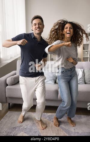 Fröhliches positives junges Ehepaar, das zu Hause Spaß hat Stockfoto