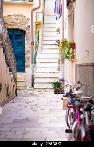 Alte Gasse mit Fahrrädern und Treppen in der Stadt Termoli, Molise, Mittelitalien. Stockfoto