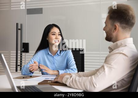 Positiver junger asiatischer Manager, der mit dem Chef spricht Stockfoto