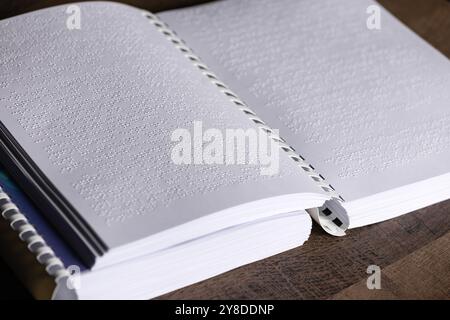 Ein in Braille geschriebenes Buch, das in Nahaufnahme fotografiert wurde und sich auf die Textur der erhöhten Punkte konzentriert. Hebt den Tastwert für die optische Beeinträchtigung hervor Stockfoto