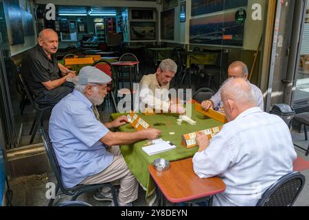 Istanbul, Türkei - 18. September 2024: Eine Gruppe von Männern spielt Okey, Rummikub, in einem Café auf dem Kadikoy-Markt in Istanbul. Stockfoto