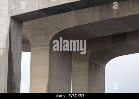 Nahaufnahme einer Betonbrücke mit gekrümmten Stützen. Stockfoto