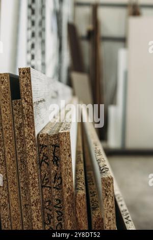 Nahaufnahme eines Stapels von Holzpaneelen mit strukturierter Körnung und Markierungen, die auf ihre Verwendung im Möbelbau hinweisen. Stockfoto