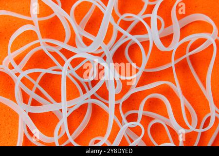 Hellblaue Gummibänder auf orangefarbenem Hintergrund Stockfoto