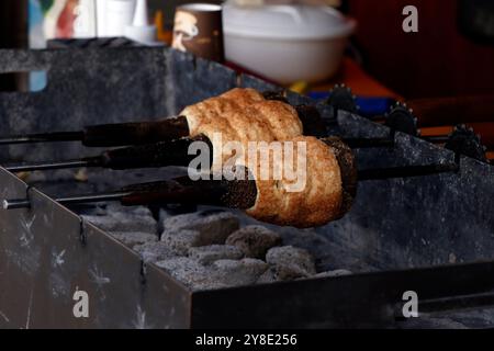 Kürtőskalács wird aus süßem Hefeteig (erhöhter Teig) hergestellt, von dem ein Streifen versponnen und dann um einen abgeschnittenen kegelförmigen Backspieß gewickelt wird, und Stockfoto