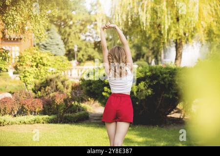 Eine junge Frau steht mit dem Rücken auf einer Natur Hintergrund Stockfoto