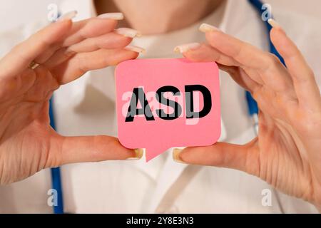 Mehrfarbige Büropapieraufkleber mit dem Text ASD Autism Spectrum Disorder auf hölzernem Hintergrund. Kopierbereich Stockfoto