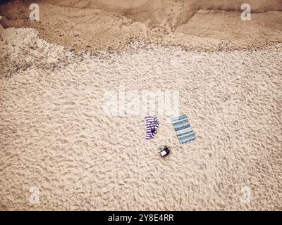 Zwei Decken liegen verlassen am Sandstrand, aus der Luft gesehen Stockfoto