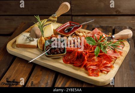 Ein wunderschön gestaltetes Gourmet-Charcuterie-Board mit einer Auswahl an Käse und Nüssen Stockfoto