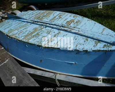 Altes hölzernes Boot mit abplattender blauer Farbe auf den Kopf gestellt Stockfoto