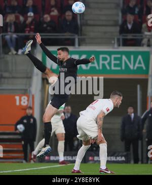 Augsburg, Deutschland. Oktober 2024. Jeffrey Gouweleeuw (R) aus Augsburg streitet mit Tim Kleindienst aus Mönchengladbach während des ersten Bundesliga-Fußballspiels zwischen dem FC Augsburg und Borussia Mönchengladbach am 4. Oktober 2024 in Augsburg. Quelle: Philippe Ruiz/Xinhua/Alamy Live News Stockfoto