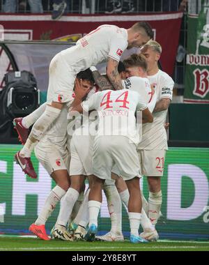 Augsburg, Deutschland. Oktober 2024. Augsburger Spieler feiern beim Fußball-Erstliga-Spiel zwischen dem FC Augsburg und Borussia Mönchengladbach in Augsburg am 4. Oktober 2024 ein Tor. Quelle: Philippe Ruiz/Xinhua/Alamy Live News Stockfoto