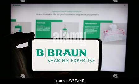 Deutschland. September 2024. In dieser Fotoabbildung hält eine Person ein Mobiltelefon mit dem Logo des deutschen Pharmaunternehmens B. Braun SE vor der Business-Website. Quelle: SOPA Images Limited/Alamy Live News Stockfoto