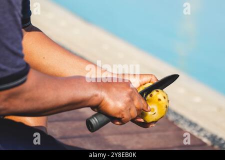 Man schneidet Ananas mit einzigartigem Stil. Tropische Früchte Kunst Stockfoto