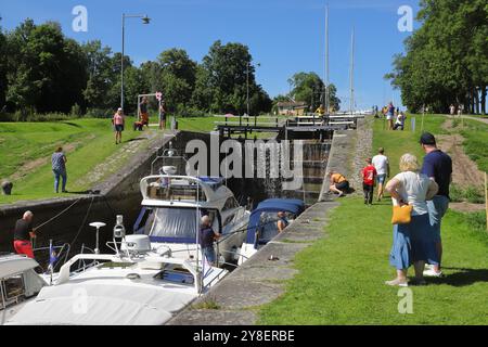 Berg, Schweden - 19. Juli 2024: Menschen beobachten, wie Freizeitboote in Bergs Schleusen im Göta-Kanal einsperren. Stockfoto