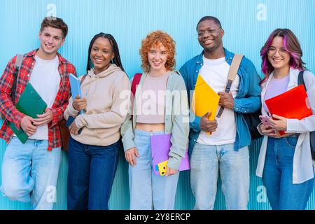 Eine Gruppe lächelnder Studenten auf dem Universitätscampus mit Notizbüchern Stockfoto