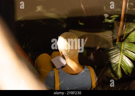Blick aus einem hohen Winkel auf eine entspannte, unveränderte, ungezwungene Geschäftsfrau, die auf der Couch sitzt und Notizen macht Stockfoto