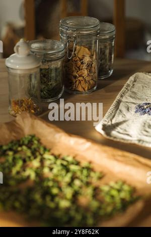 Getrocknete Blumen und Kräuter in verschlossenen Glasgläsern auf einem Holztisch gelagert. Für den Wintereinsatz vorbereitet Stockfoto