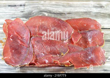 Dünne Scheiben Rindfleisch-Pastrami, aus Rinderbrust hergestellt, rohes Fleisch wird gebraten, teilweise getrocknet, mit Kräutern und Gewürzen gewürzt, dann geräuchert und gedünstet, li Stockfoto