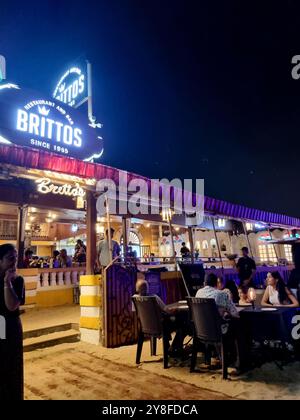 Weitwinkelaufnahme mit der berühmten Hütte Brittos am Strand von baga mit bunten Lichtern und einer Menge von Touristen, die ein Abendessen auf Sandkaraoke und mehr genießen Stockfoto